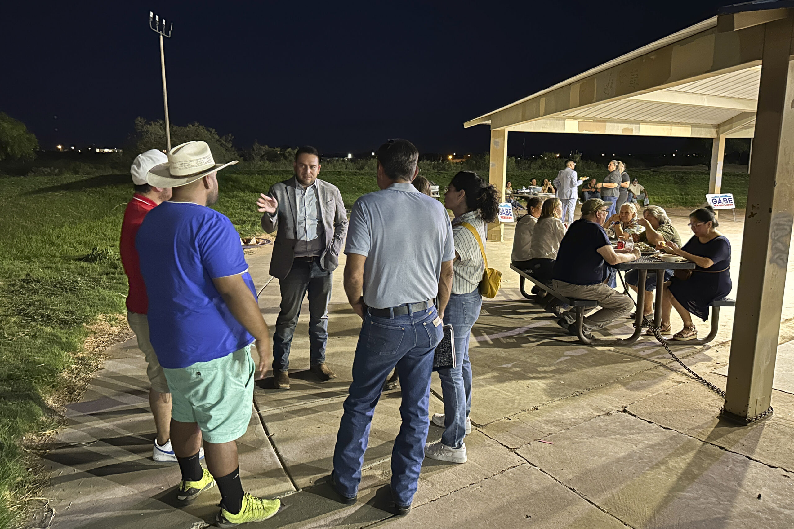 Rep. Gabe Vasquez, D-N.M., holds up a hand as he talks to guests at a "carne asada" campaign pickni...