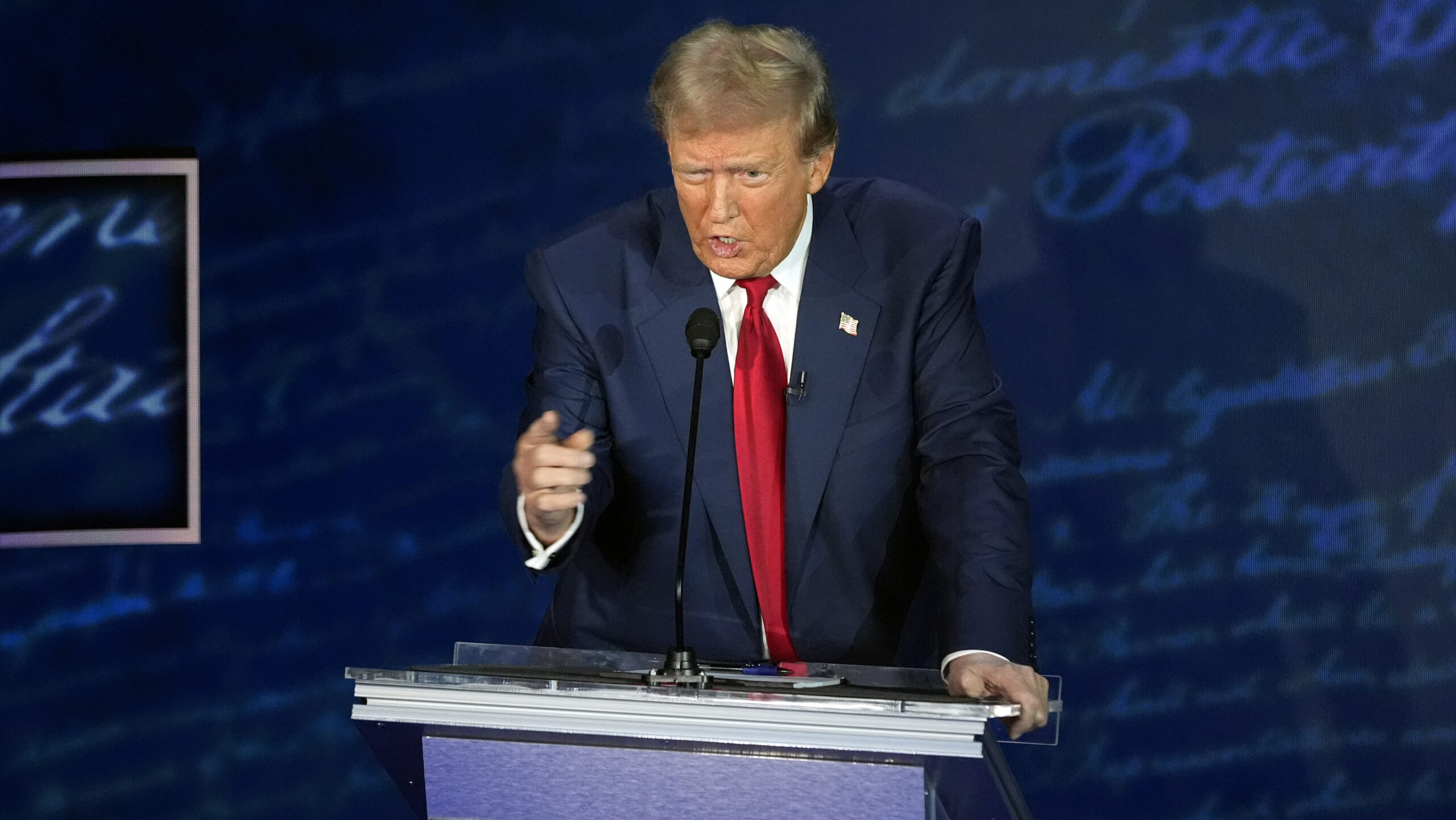 Donald Trump pointing at a podium...