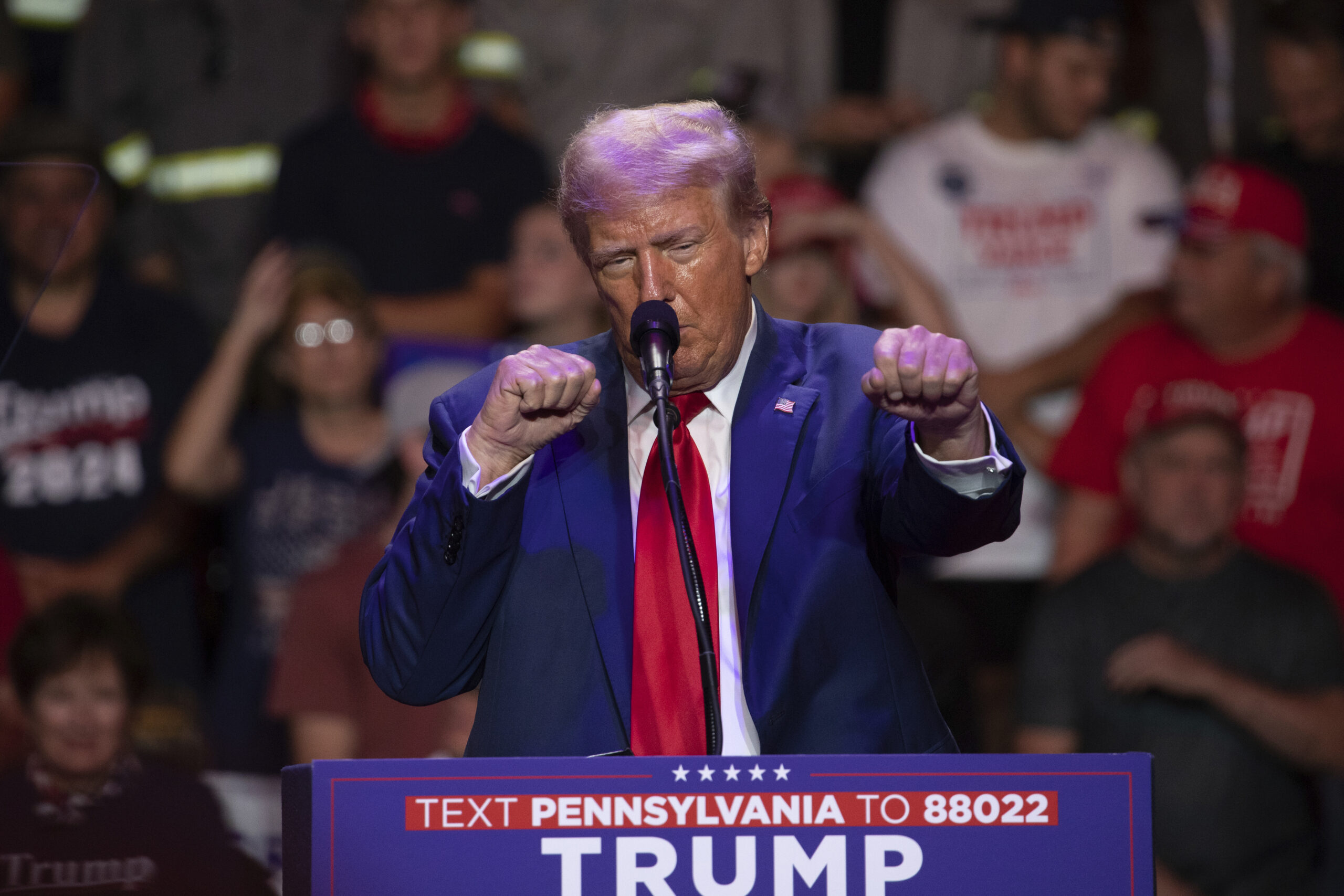 Republican presidential nominee former President Donald Trump makes a boxing gesture as he talks wo...