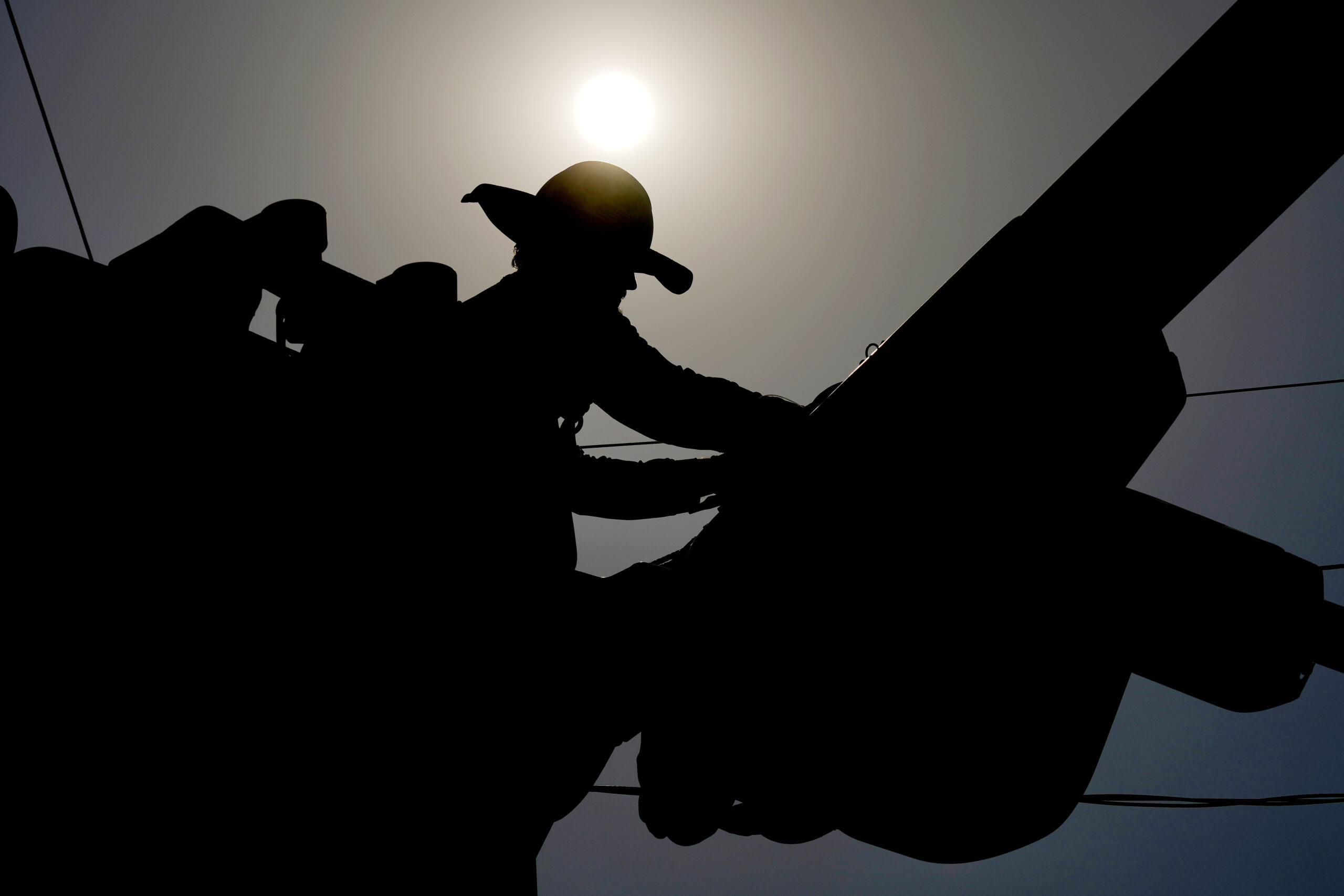 FILE - A linesman works on power lines under the morning sun, July 12, 2024, in Phoenix. (AP Photo/...