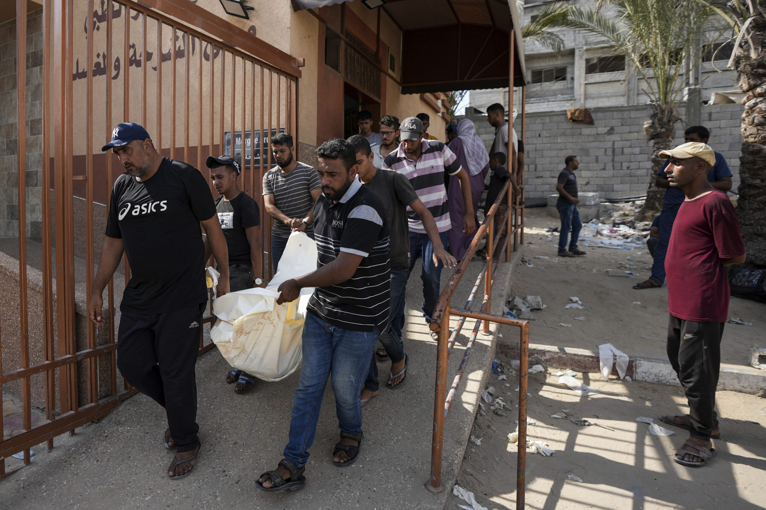 Mourners carry the covered bodies of Palestinians who were killed in an Israeli airstrike on a crow...