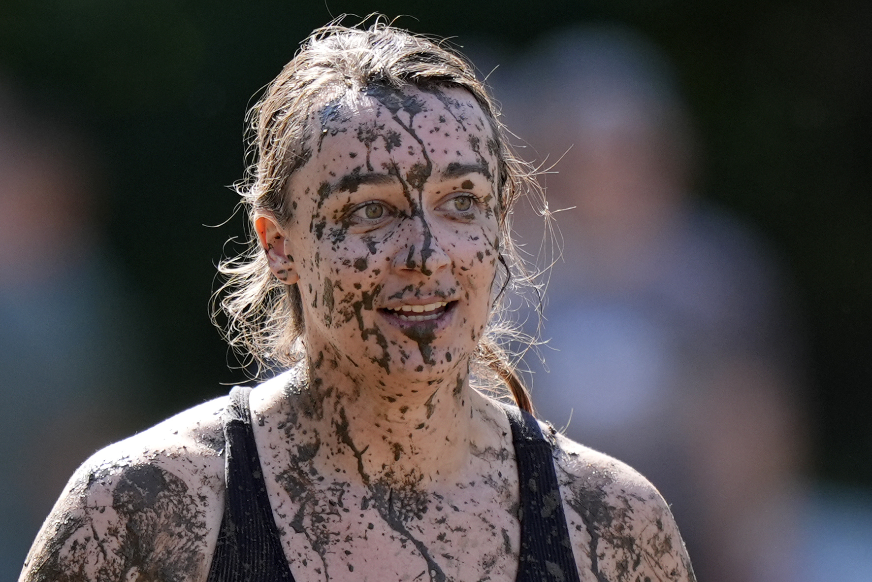 Amanda Lackey, of Bow, N.H., is splattered with mud as she walks back to the huddle during a women'...