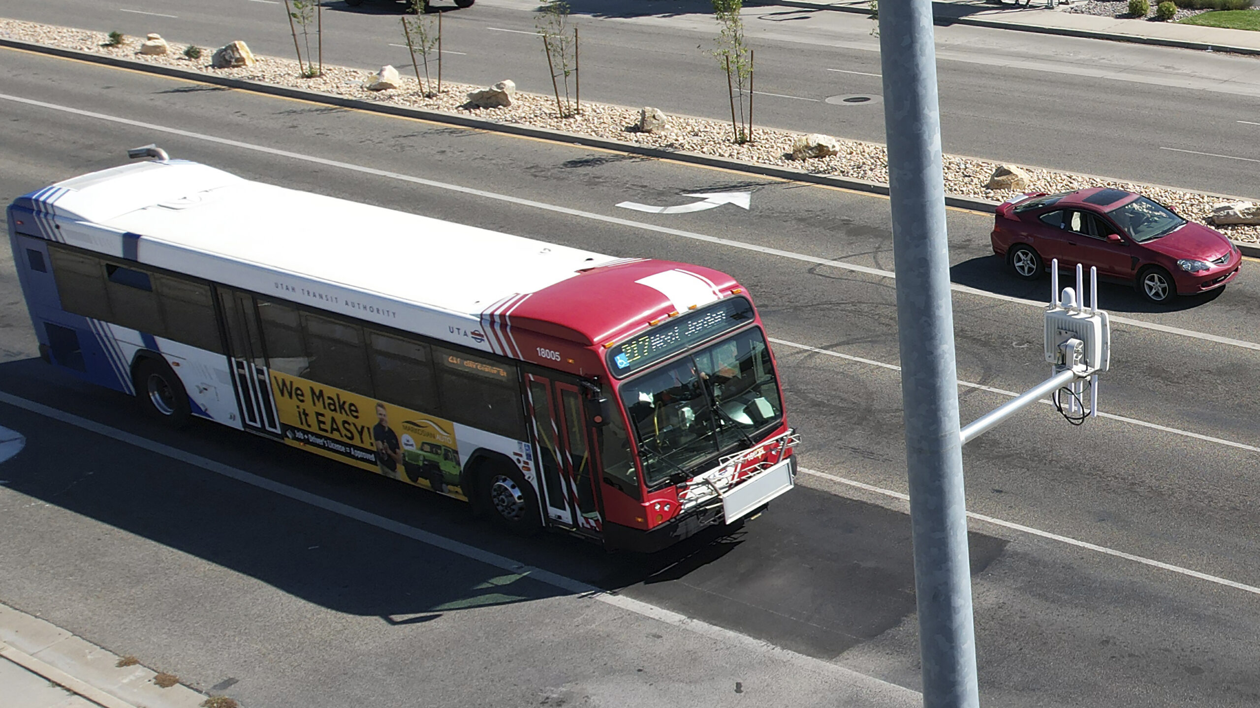 A commuter bus equipped with a radio transmitter approaches a connected traffic light on Redwood Ro...