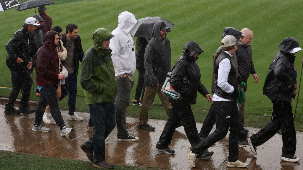 Fans walk the course in the rain during the first round of the WM Phoenix Open at TPC Scottsdale on...