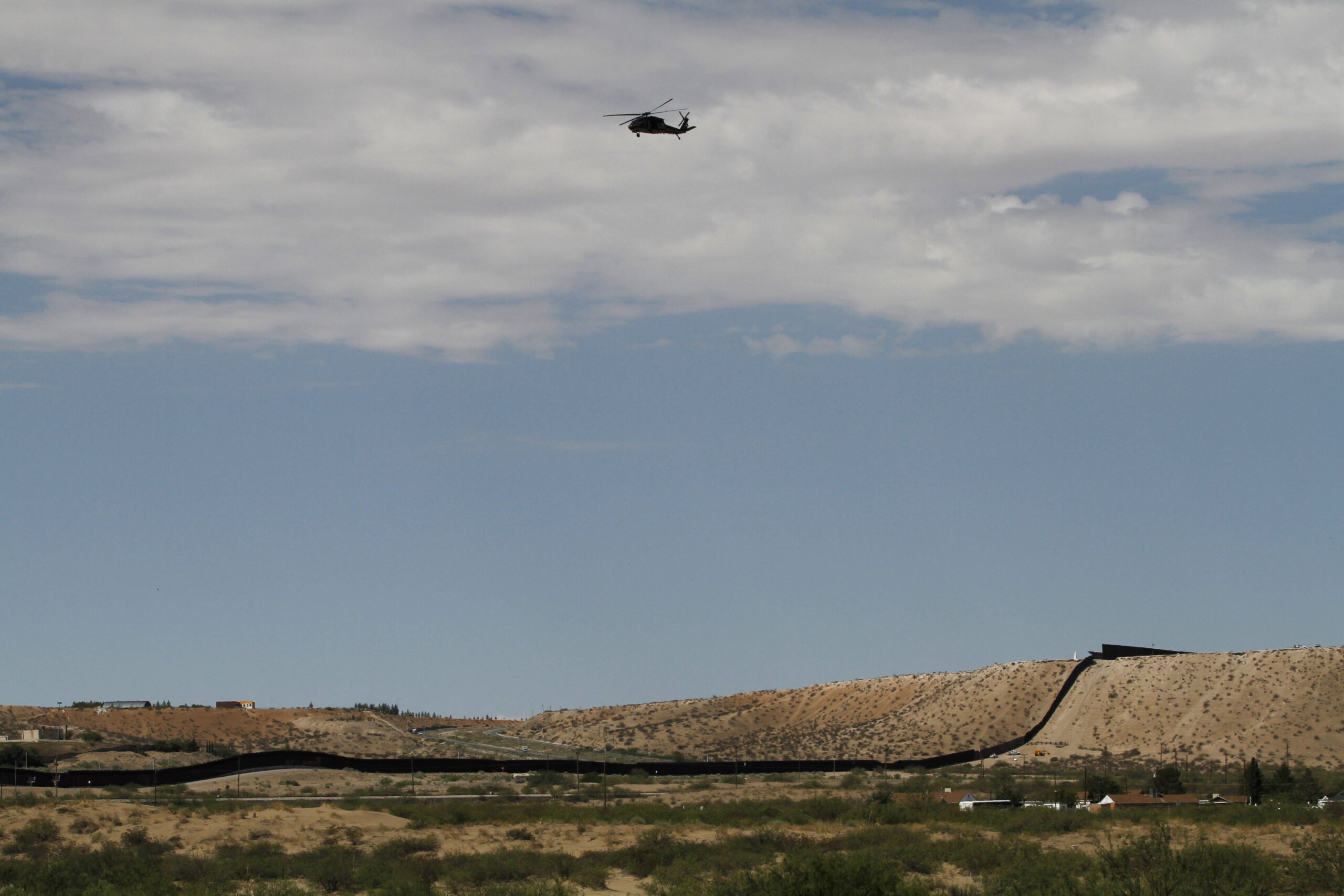 A surveillance helicopter traces a line in the sky above the Southwest border with Mexico at Sunlan...