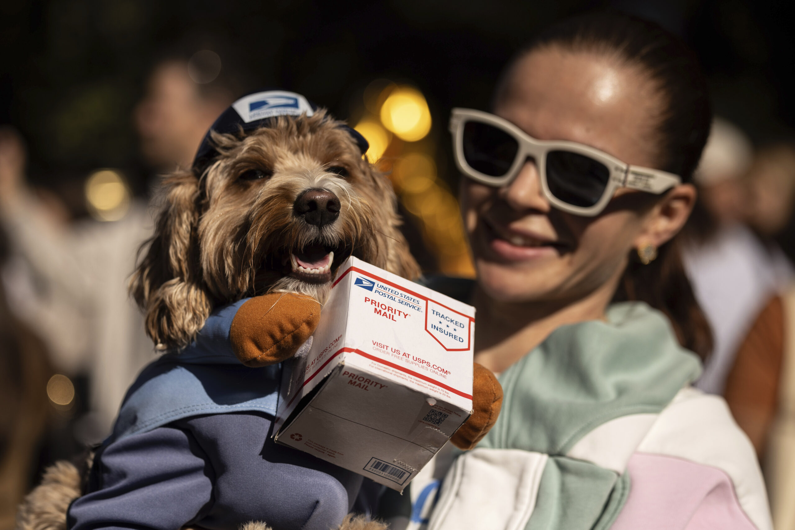 A person poses for photos with their dogs in costume during the 34th annual Tompkins Square Hallowe...