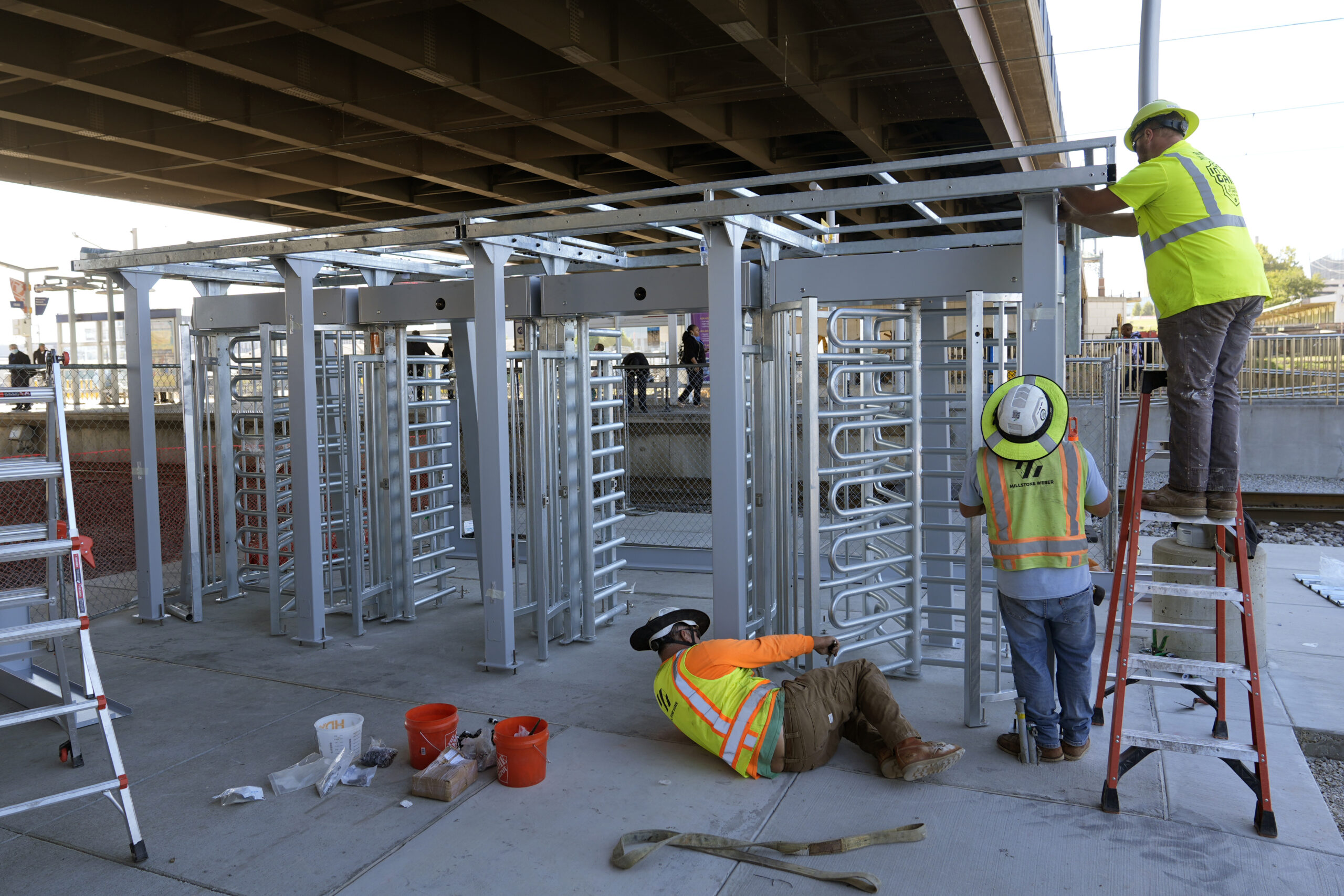 Workers install a metal gate that will prevent customers from entering a MetroLink platform without...