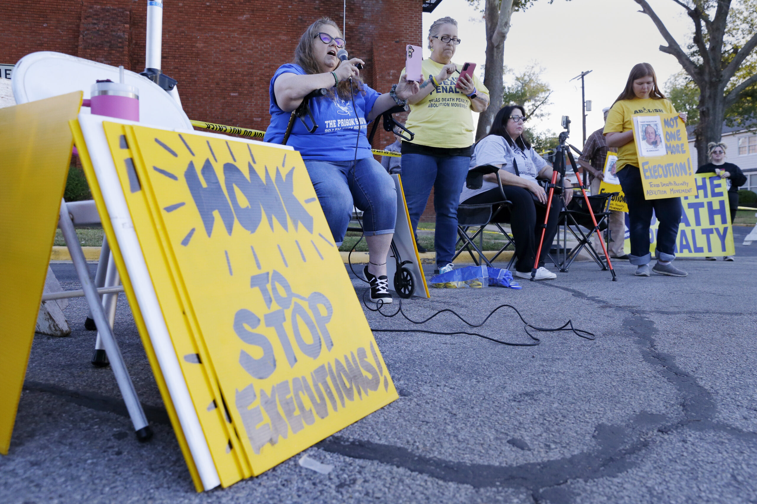 Dani Allen, center left with microphone, an anti-death penalty advocate, speaks during a protest ou...