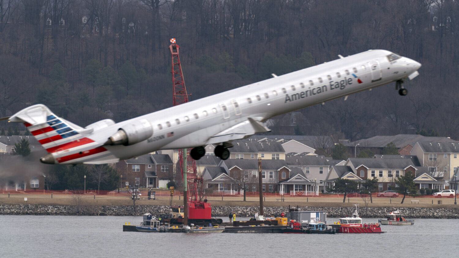 Salvage crews work on recovering wreckage near the site in the Potomac River of a mid-air collision...