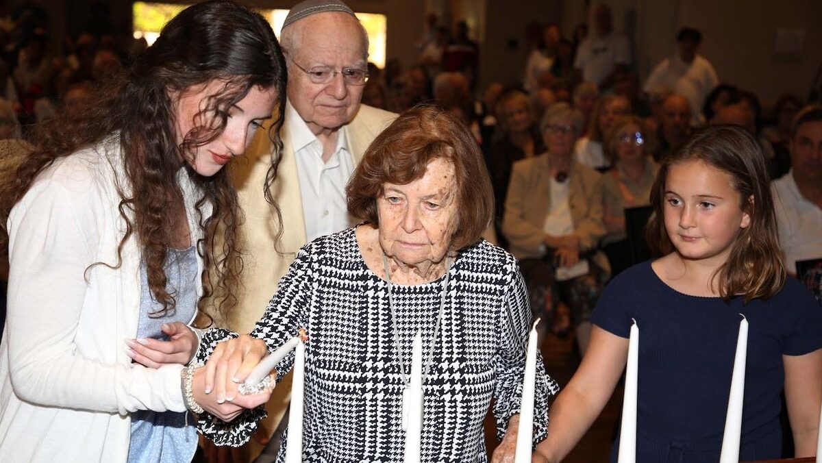 Survivor Charlotte Adelman and 4th generation Chloe Markowitz and Olivia Feldman lighting the candl...