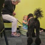 Therapy dog Maire listens to kids read during the Sit, Stay, read program. (Shira Tanzer/KTAR News)