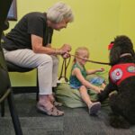 Therapy dog Maire listens to kids read during the Sit, Stay, read program. (Shira Tanzer/KTAR News)