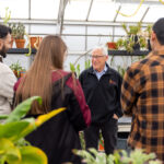 Rob Walton talks with ASU students in a greenhouse on Feb. 12, 2025. (Samantha Chow/Arizona State University)