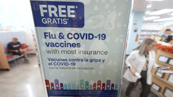 A sign advertises seasonal flu and COVID-19 vaccines at a CVS Pharmacy in Miami, Florida. (AP Photo/Rebecca Blackwell)