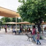 Concept art of an outdoor space with people sitting under umbrellas and a woman, child and dog in the center // Credit: City of Chandler