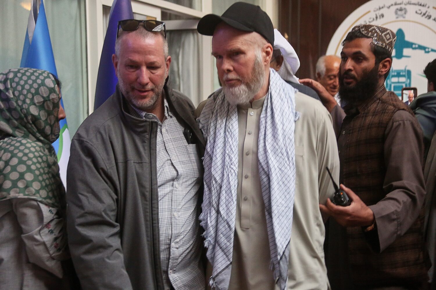 American Dennis Coyle, second from right, is accompanied by an unidentified person after being rele...