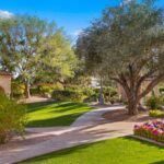 Towering palm trees and manicured greenery surround the property, giving the grounds a serene, park like atmosphere rarely found in Paradise Valley.