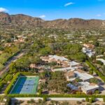 The estate’s expansive four acre grounds unfold like a private resort, framed by lush lawns, mature trees, and sweeping views of Camelback Mountain.