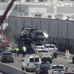 A crane was brought onto a Phoenix freeway to secure a trailer filled with cars that was dangling over a guard rail. (ADOT photo)