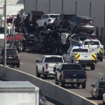 A car hauler sits on the side of I-17 in Phoenix after a crane pulled it off a guard rail. (ADOT photo)