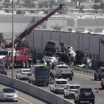 A crane was brought onto a Phoenix freeway Thursday to secure a trailer filled with cars that was dangling over a guard rail after a crash. (ADOT photo)