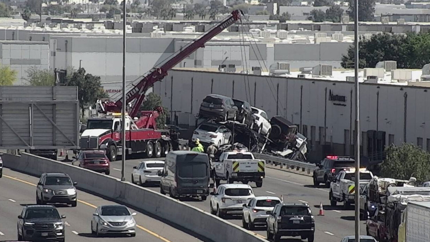 A crane was brought onto a Phoenix freeway Thursday to secure a trailer filled with cars that was d...