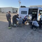 A Circle the City medical worker examines a patient outside the nonprofit's mobile unit at a Phoenix park. The city is considering an ordinance that would require permits for medical treatment in parks. (Credit: Balin Overstolz-McNair)