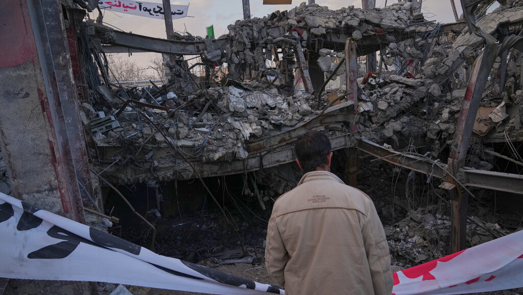 A man looks at a destroyed building within the Grand Hosseiniyeh complex that officials say was hit...