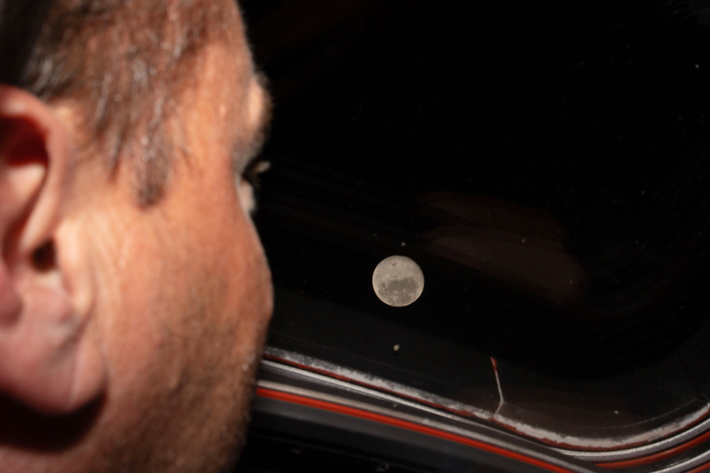 In this photo provided by NASA, Artemis II commander and NASA astronaut Reid Wiseman looks out one ...