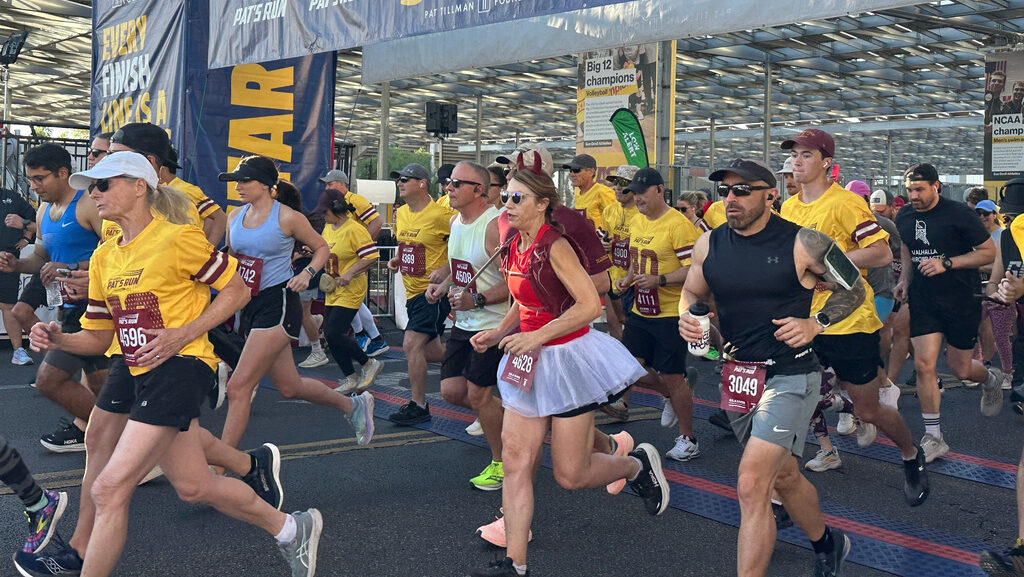Runners take off at the start line of Pat's Run, a 4.2-mile race honoring former NFL player and Arm...