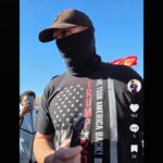 Sgt. Dusten Mullen, armed and wearing a face covering, stands near Hamilton High School students during an anti-ICE walkout protest in Chandler on Jan. 29, 2026. (Courtesy @turbo_rep on TikTok)