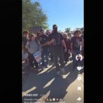 Sgt. Dusten Mullen, armed and wearing a face covering, stands near Hamilton High School students during an anti-ICE walkout protest in Chandler on Jan. 29, 2026. (Courtesy @turbo_rep on TikTok)