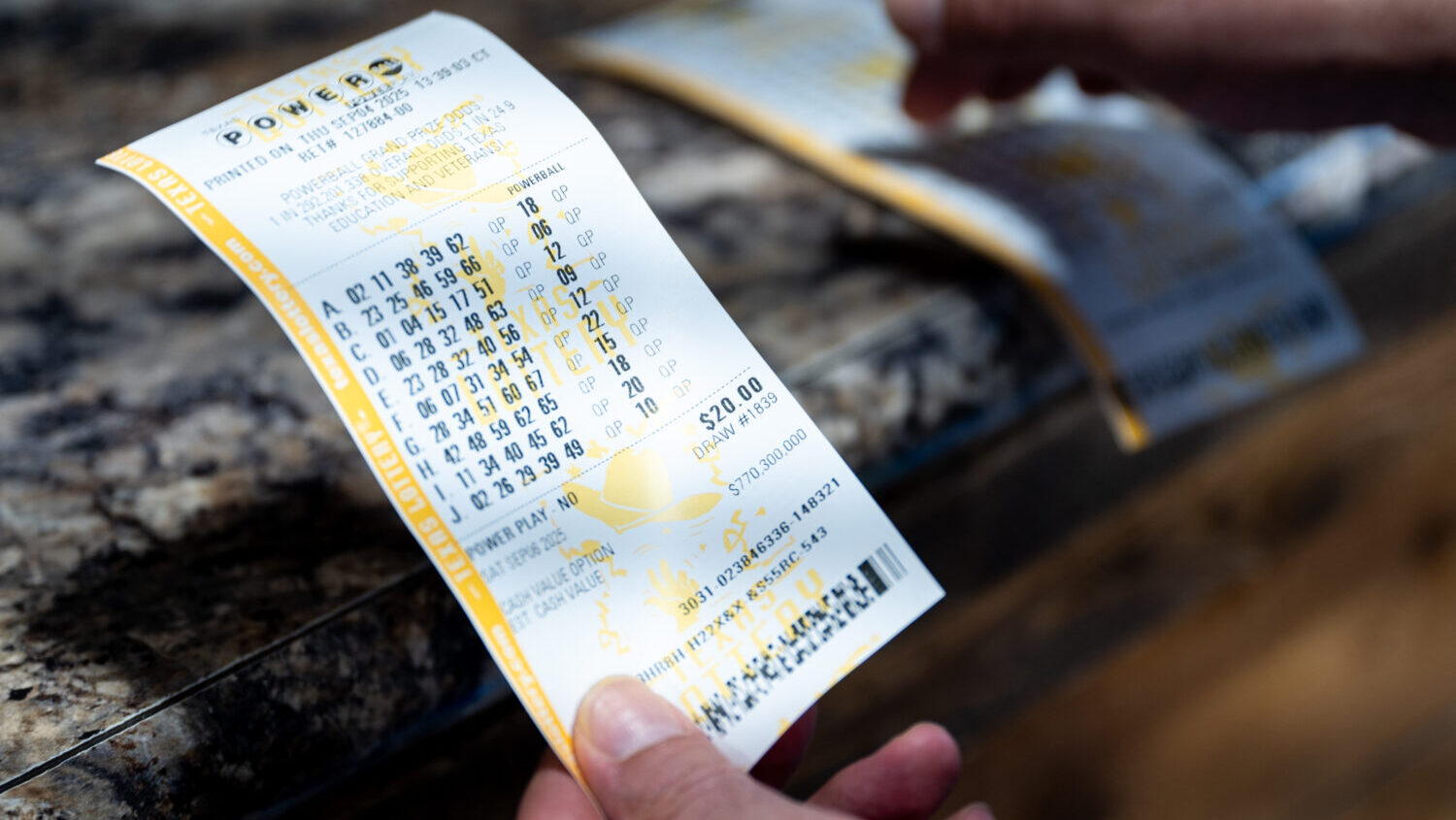 A person holds Powerball lottery tickets they purchased at the Brew Market & Cafe on September ...