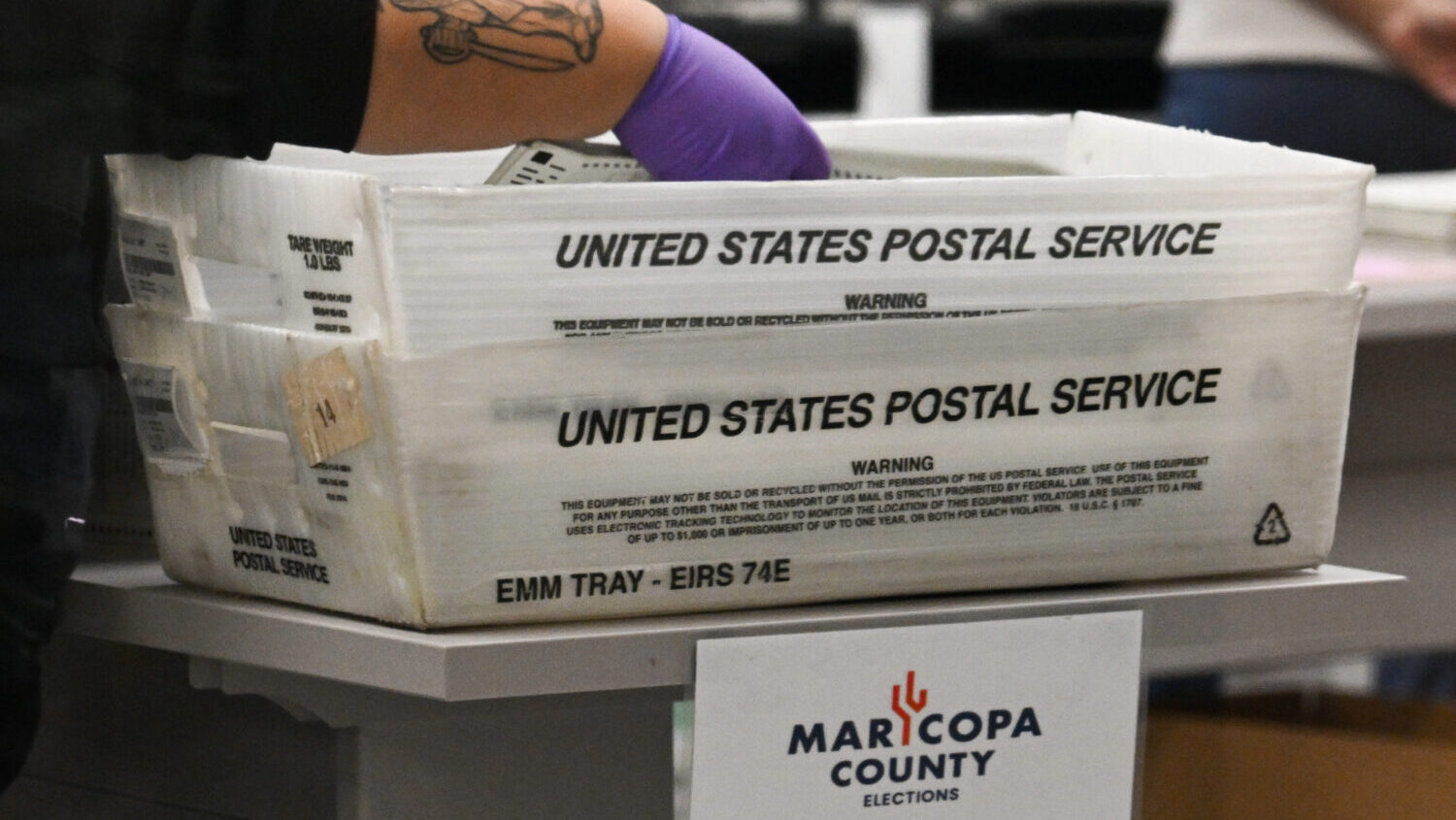 An election worker monitors a tabulation machine counting ballots at the Maricopa County Tabulation...