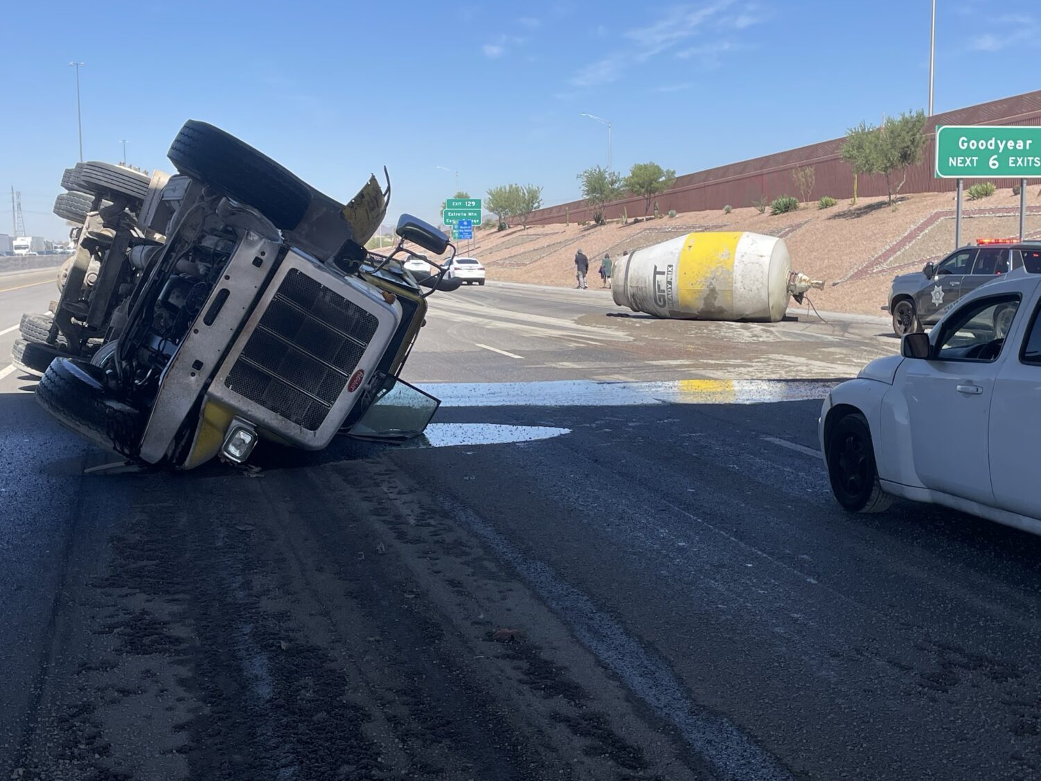 Crews work to clean up an overturned cement truck that spilled fresh concrete across westbound I-10...