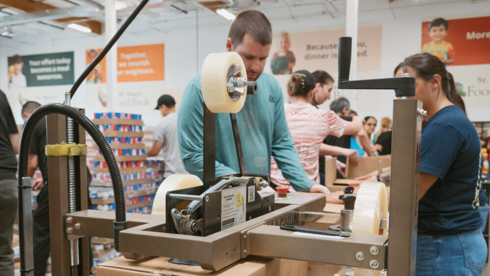 A volunteer loads a food box at St. Mary's Food Bank in Phoenix on June 17, 2026, following a donat...