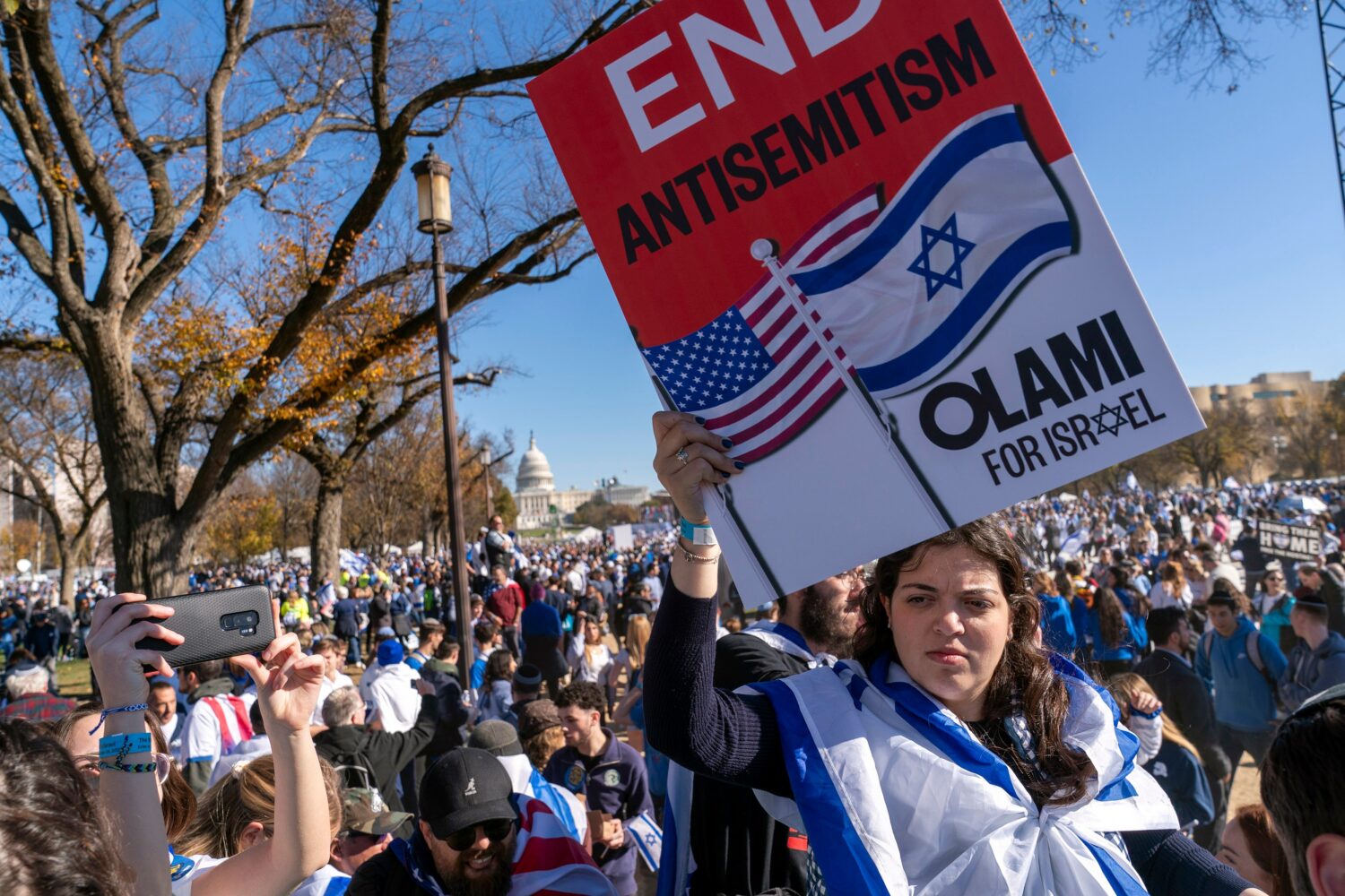FILE - A woman holds a sign saying, "end antisemitism" while attending a March for Israel rally Nov...