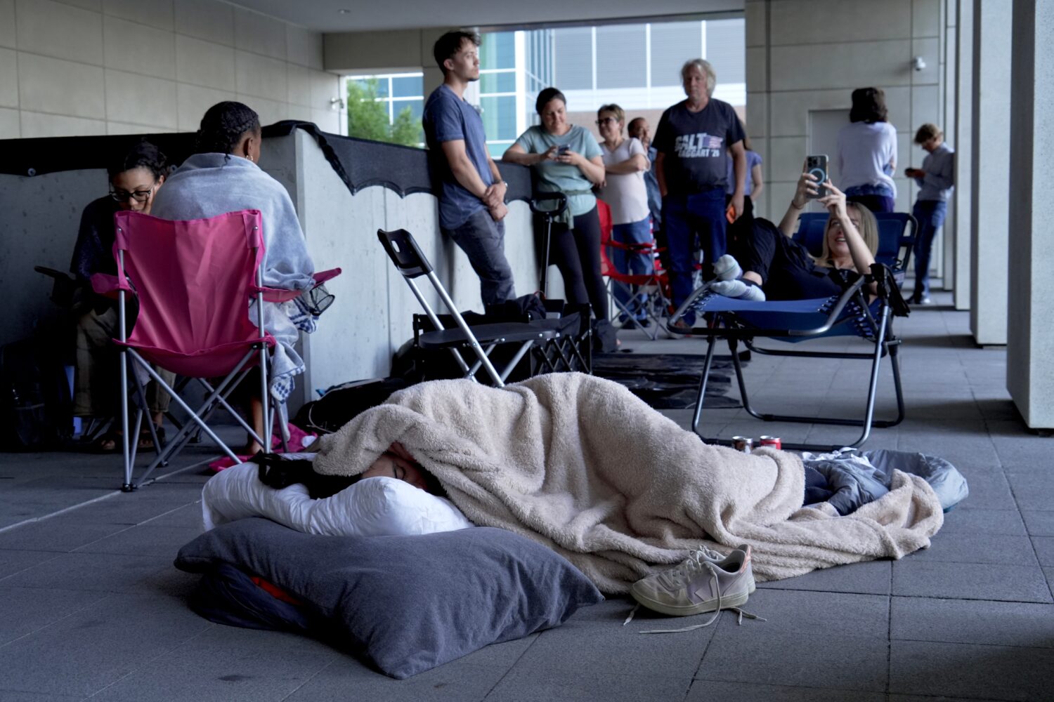 A woman sleeps outside the courthouse in hopes to get access to the limited public seating availabl...
