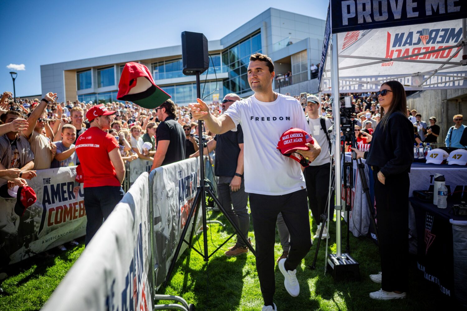 FILE - Charlie Kirk hands out hats before speaking at Utah Valley University in Orem, Utah, Sept. 1...