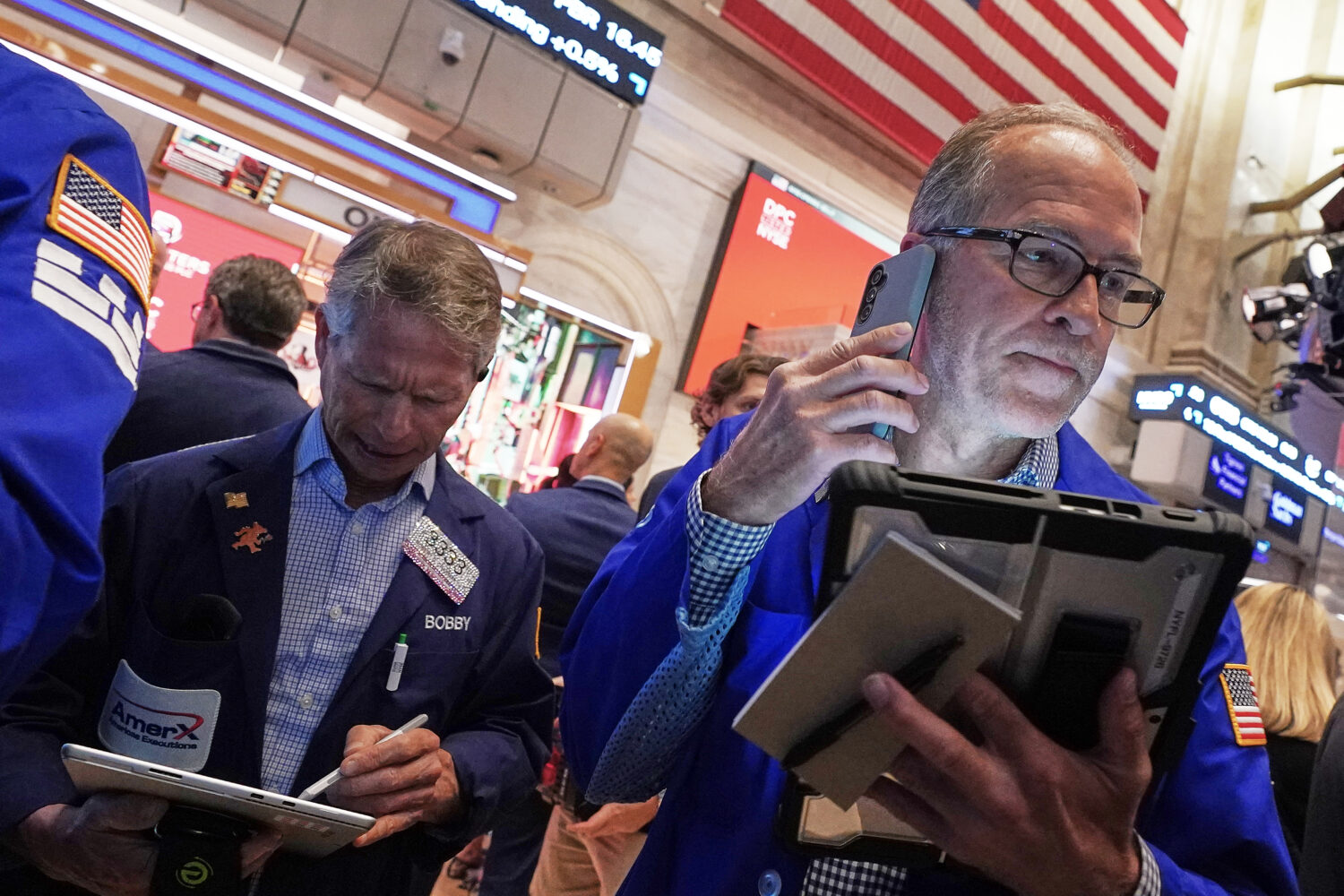 Traders Robert Charmak, left, and Mark Puetzer work on the floor of the New York Stock Exchange, Th...