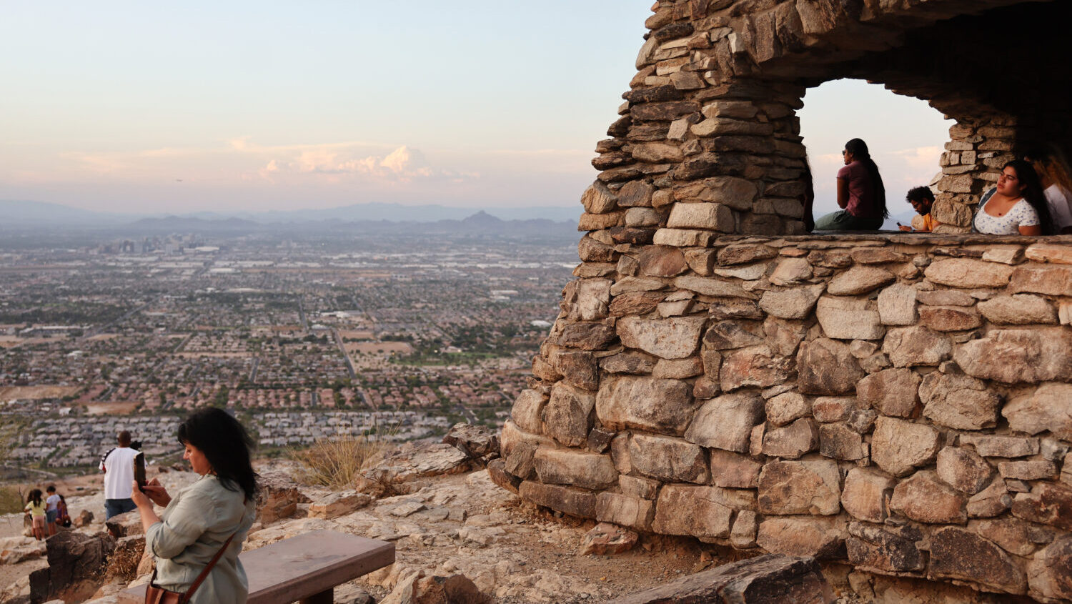 PHOENIX, ARIZONA - JULY 25: People gather and watch the sunset from South Mountain Park amid the ci...