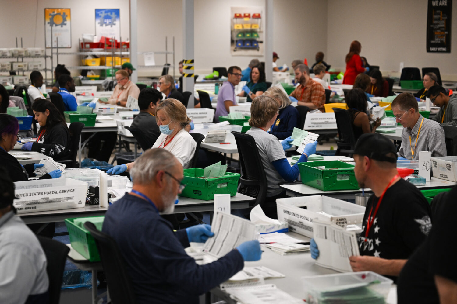 TOPSHOT - Pairs of election workers from different political parties open and inspect mail-in ballo...