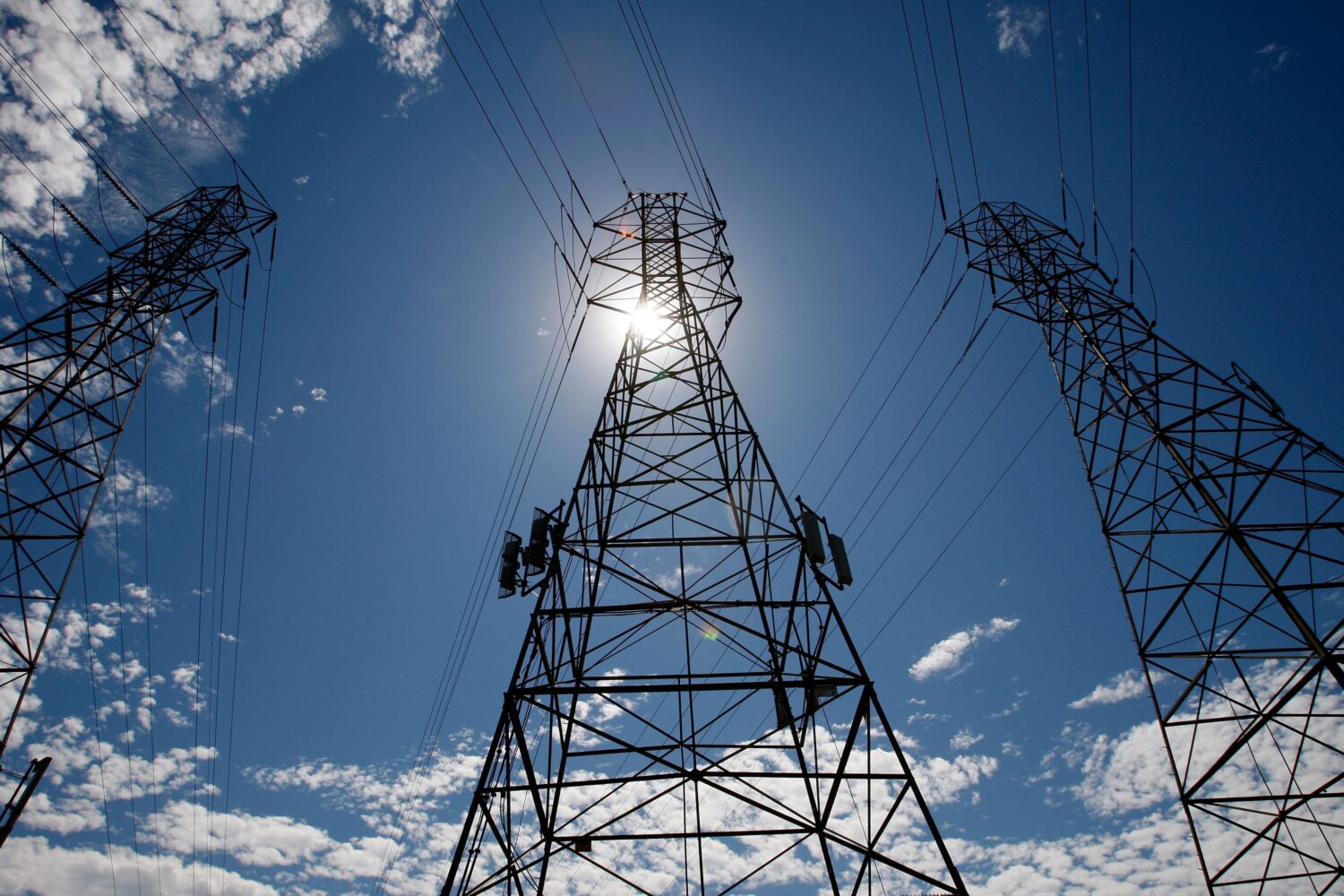 In this Aug. 30, 2007, file photo, the sun shines over towers carrying electrical lines during extr...