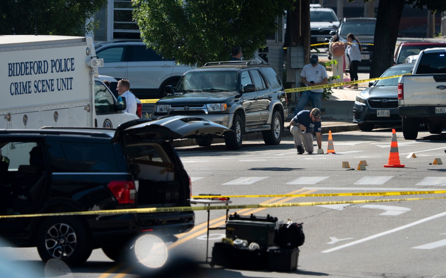 An FBI official places an evidence card where a man was reportedly killed in a shooting involving U...