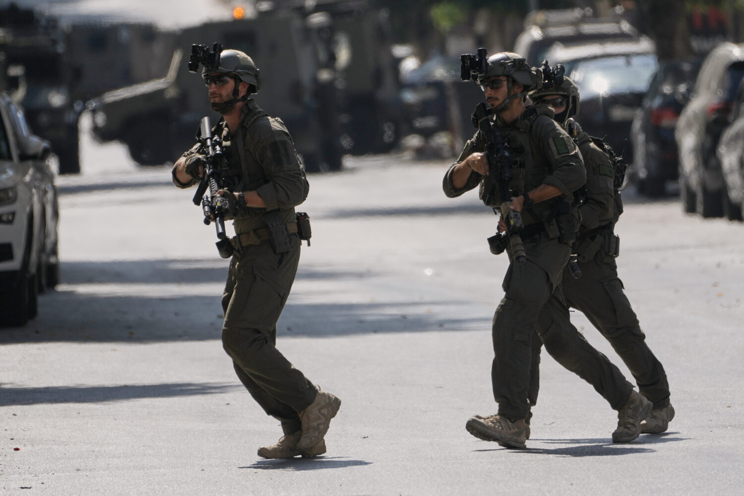 Israeli soldiers move on a street outside the Nablus Speciality Hospital in the West Bank city of N...