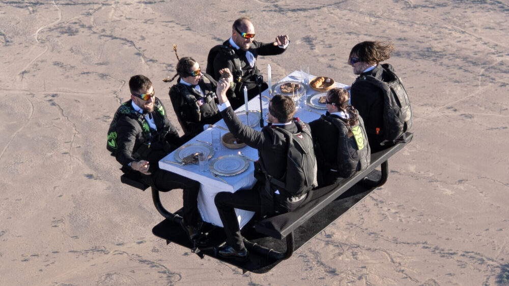 Daredevils with Nitro Circus sat at a fully set dinner table while freefalling 13,000 feet in Arizo...