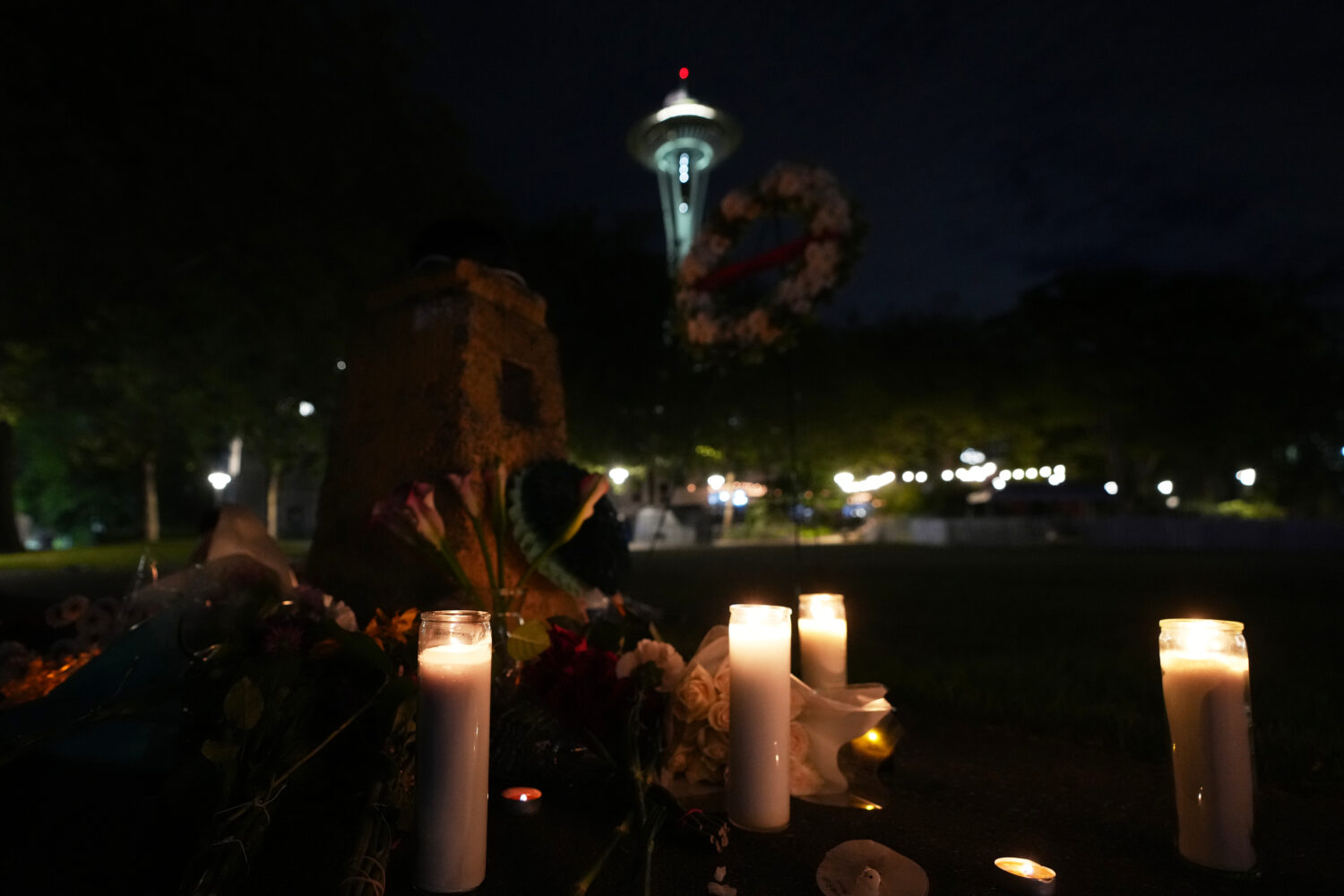 Flowers and candles are seen placed with the Space Needle at background, during the vigil for victi...
