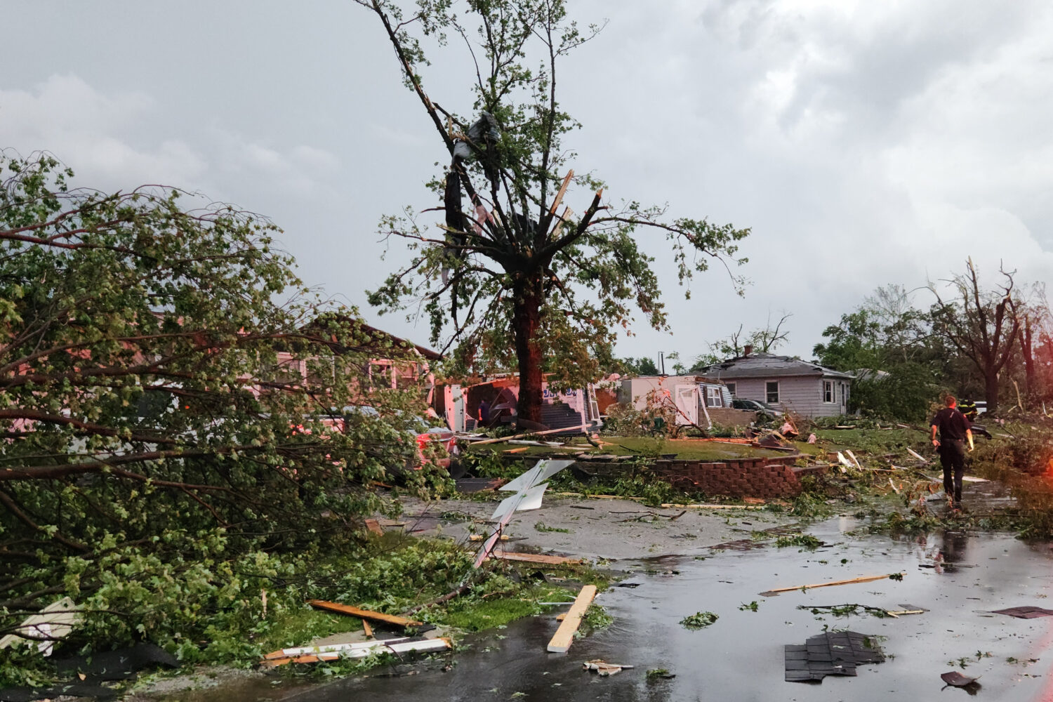 First responders walk through debris on Thursday, June 11, 2026 after a tornado passed through Merr...