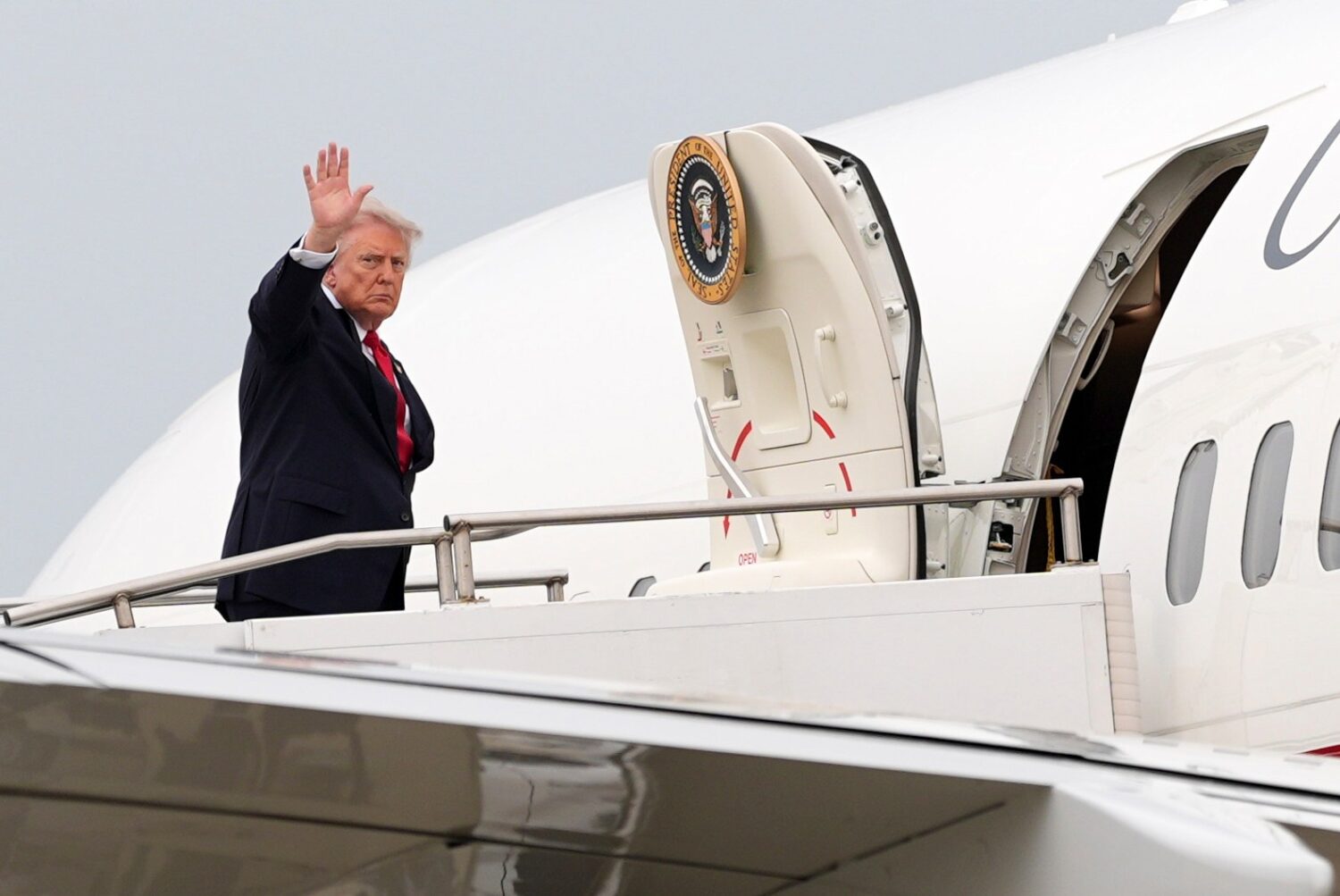 President Donald Trump waves as he departs on Air Force One at Oakland County International Airport...