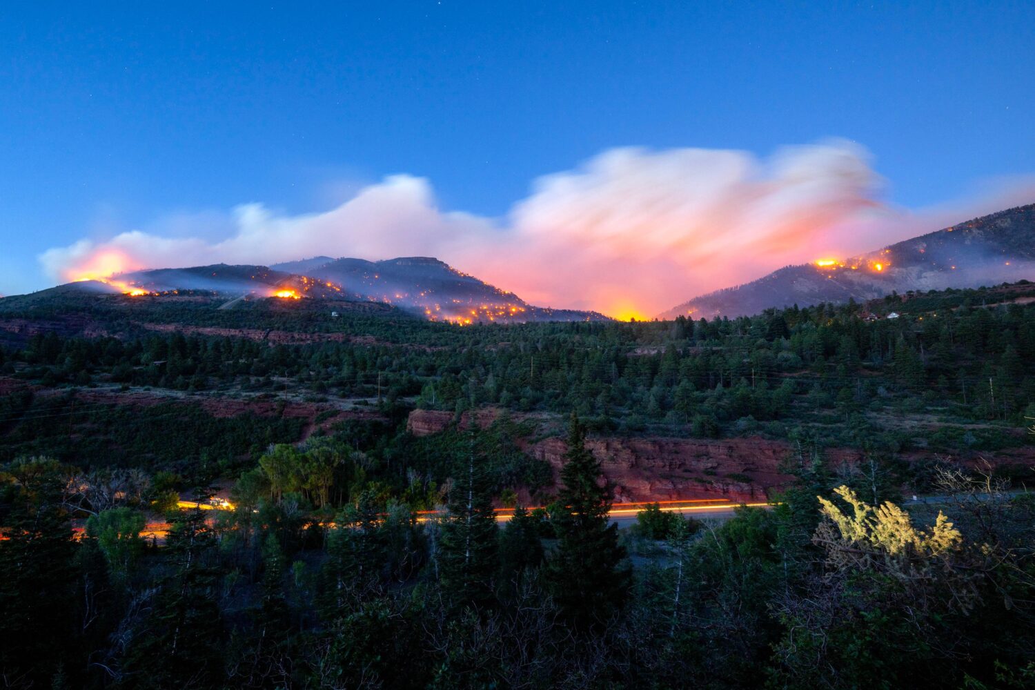 Firefighters drive along Highway 550 as they try to access the Gold Mountain Fire on the town line ...